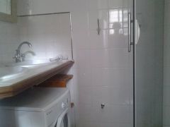 La salle d'eau est équipée de deux vasques de lavabo, d'une douche et d'un lave linge