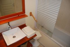 salle de bain avec baignoire, vasque, wc, sèche serviettes et sèche cheveux