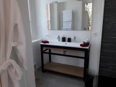 Belle salle de bain moderne avec fenêtre, radiateur sèche-serviettes, douche à l'italienne, peignoirs, sèche-cheveux et produits d'accueil bio